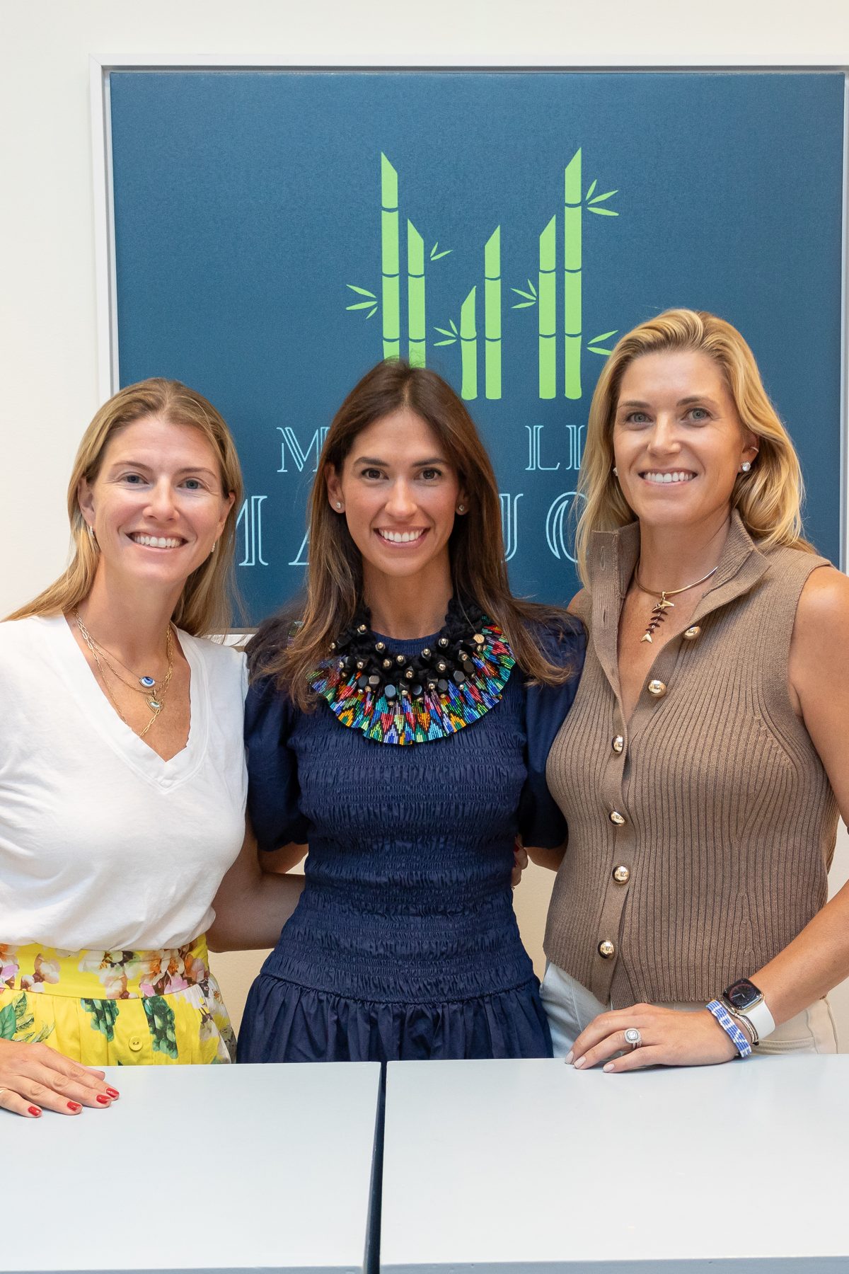 Co-founders Suzett Hamilton, Megan Boss and Karla Crockett in front of the Main Line Mahjong sign