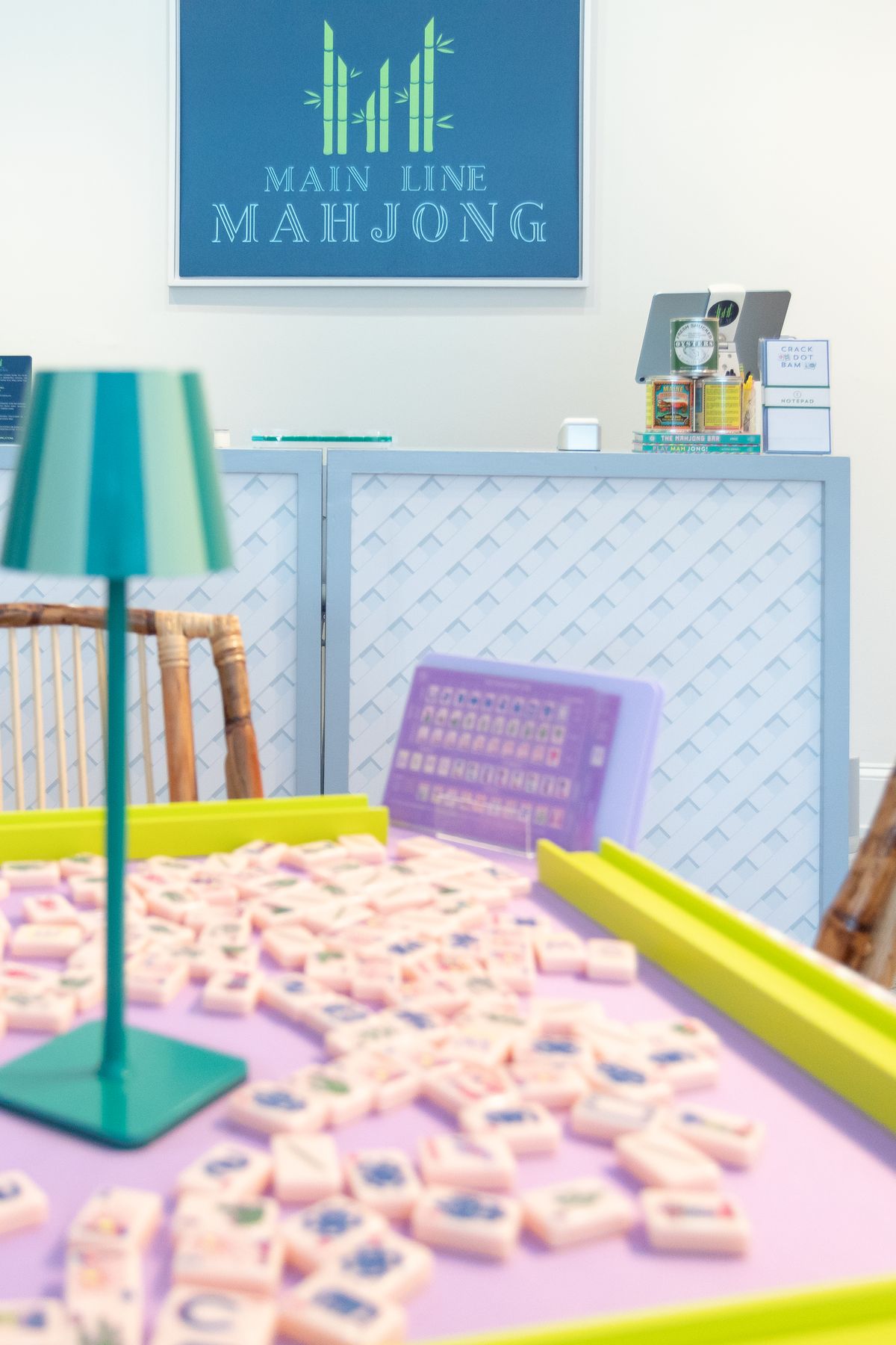 A table set with tiles beneath the Main Line Mahjong sign