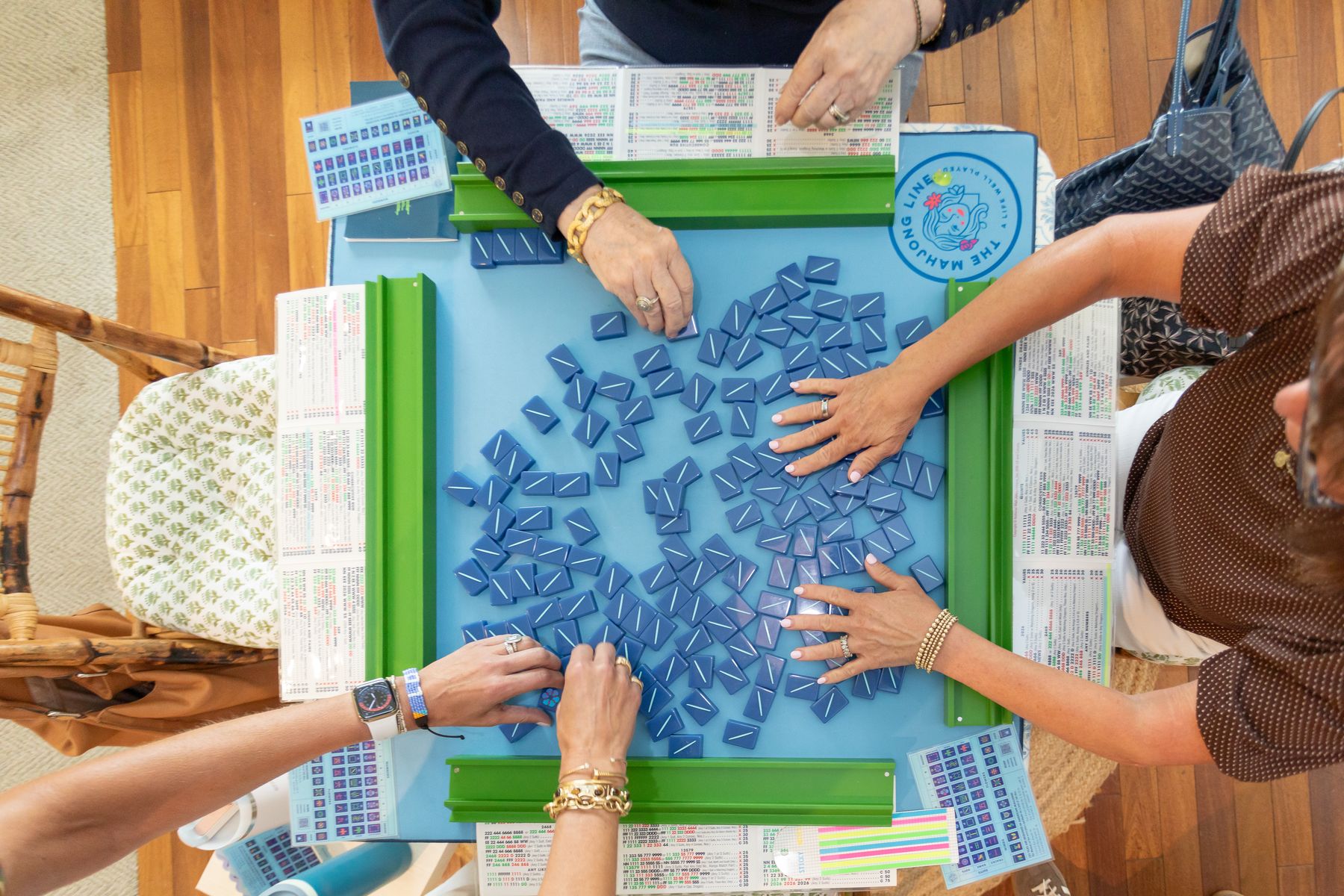 Players building their walls of tiles at a Main Line Mahjong table